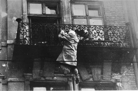  Femme accrochée à un balcon et qui va se jeter dans le vide à l'arrivée des SS. 