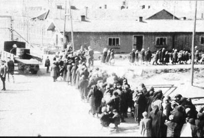 colonne de femmes et d'enfants vient d'arriver d'un train et marche vers la salle de déshabillage de la chambre à gaz